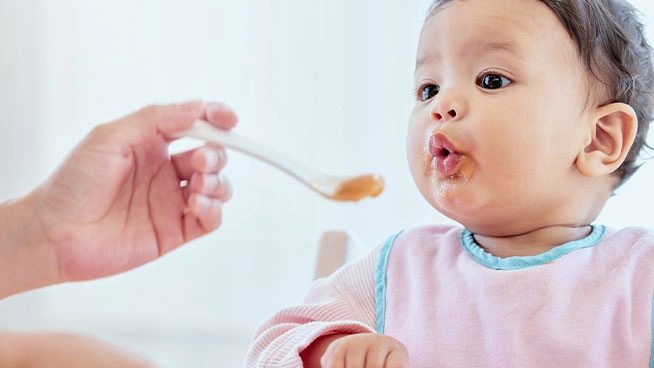 Bebé siendo alimentado con cuchara