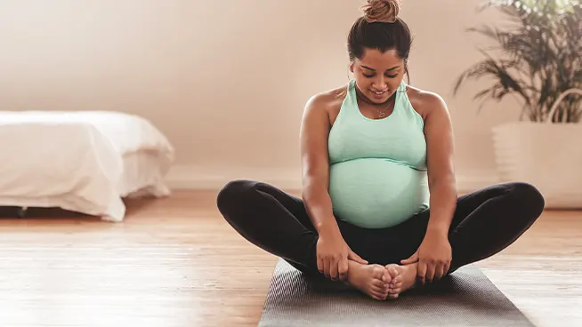 Woman doing prenatal yoga in her living room