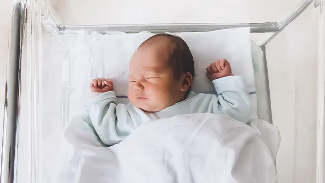 Newborn baby in hospital bassinet