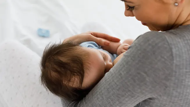 Mom cradling newborn while breast feeding