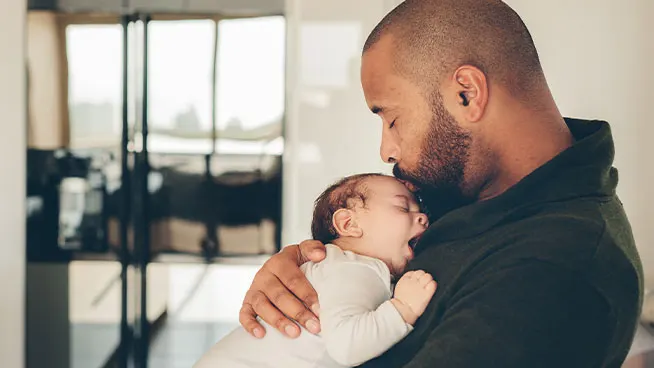 Papá sosteniendo al bebé dormido