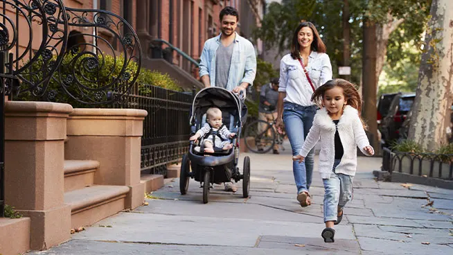 Familia en un tranquilo paseo juntos por una acera de la ciudad