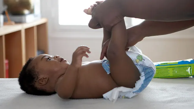 Mom changing baby's diaper