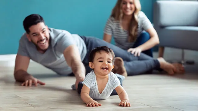 Mom and dad playing with baby on the carpet