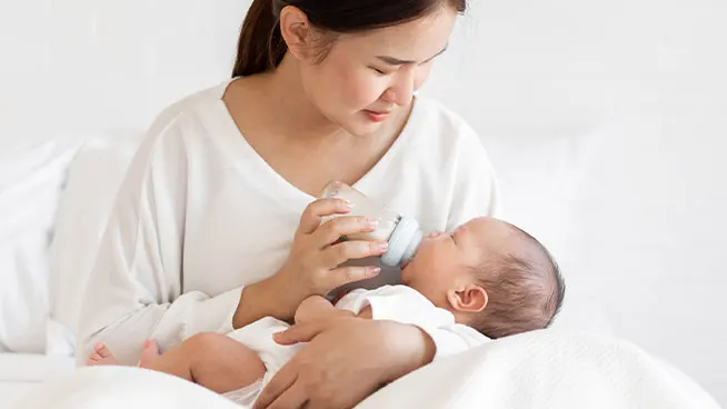 Mom cradling baby and bottle feeding