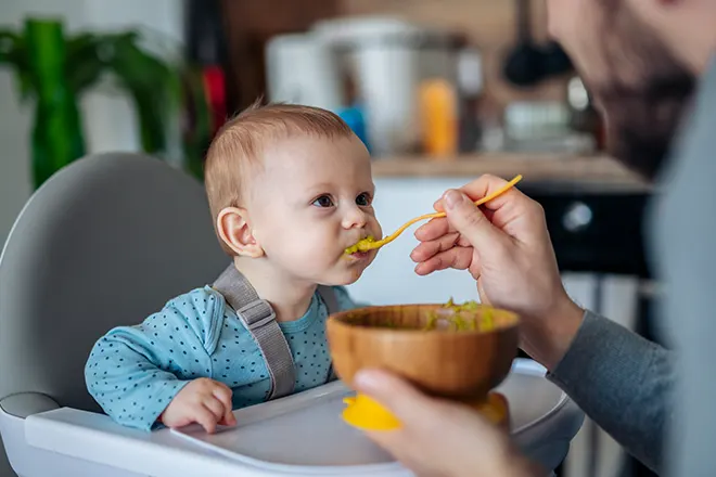 Papá alimentando comida para bebés