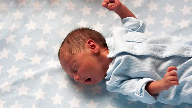 Premature baby on blanket yawning