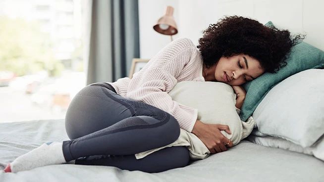 Woman curled up in bed