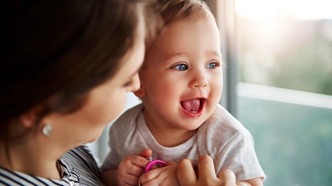 Mom holding happy toddler