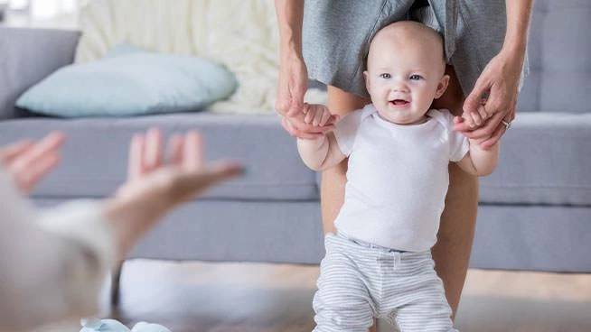 Dad and mom teaching baby how to walk