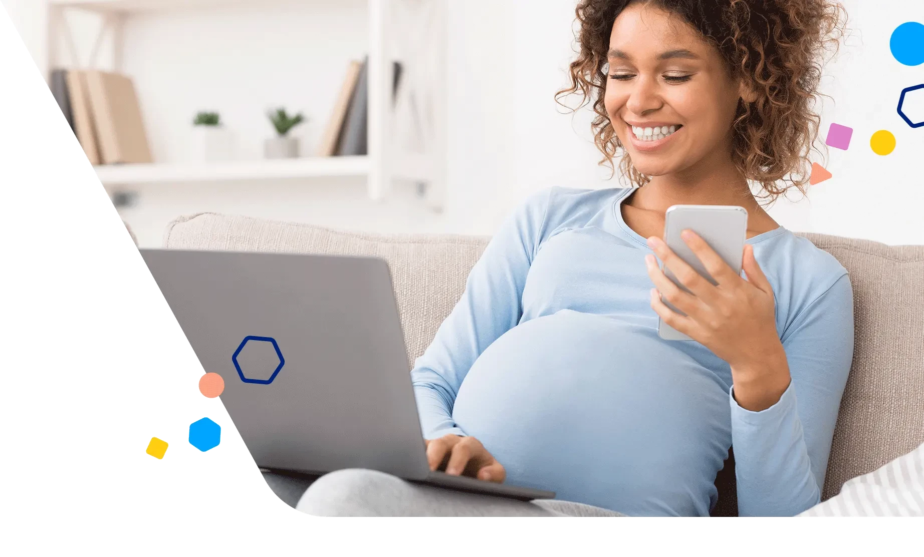 Pregnant woman sitting on the couch using her laptop and phone