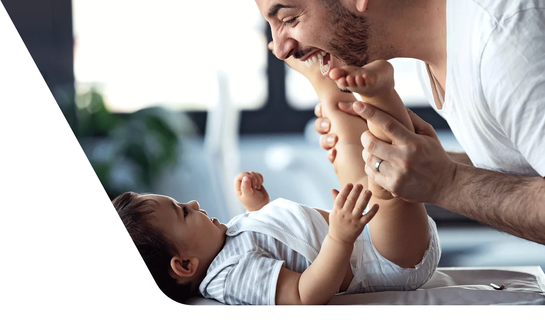 Dad playing peekaboo with newborn