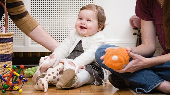 Parents and baby on the floor playing with toys