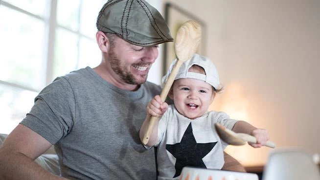 10 month milestones: dad and toddler son pretending to play the drums.