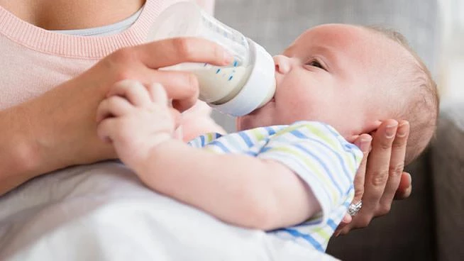 Mamá alimentando al bebé con un biberón