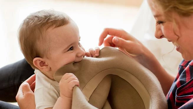 Baby putting mom's hat in her mouth