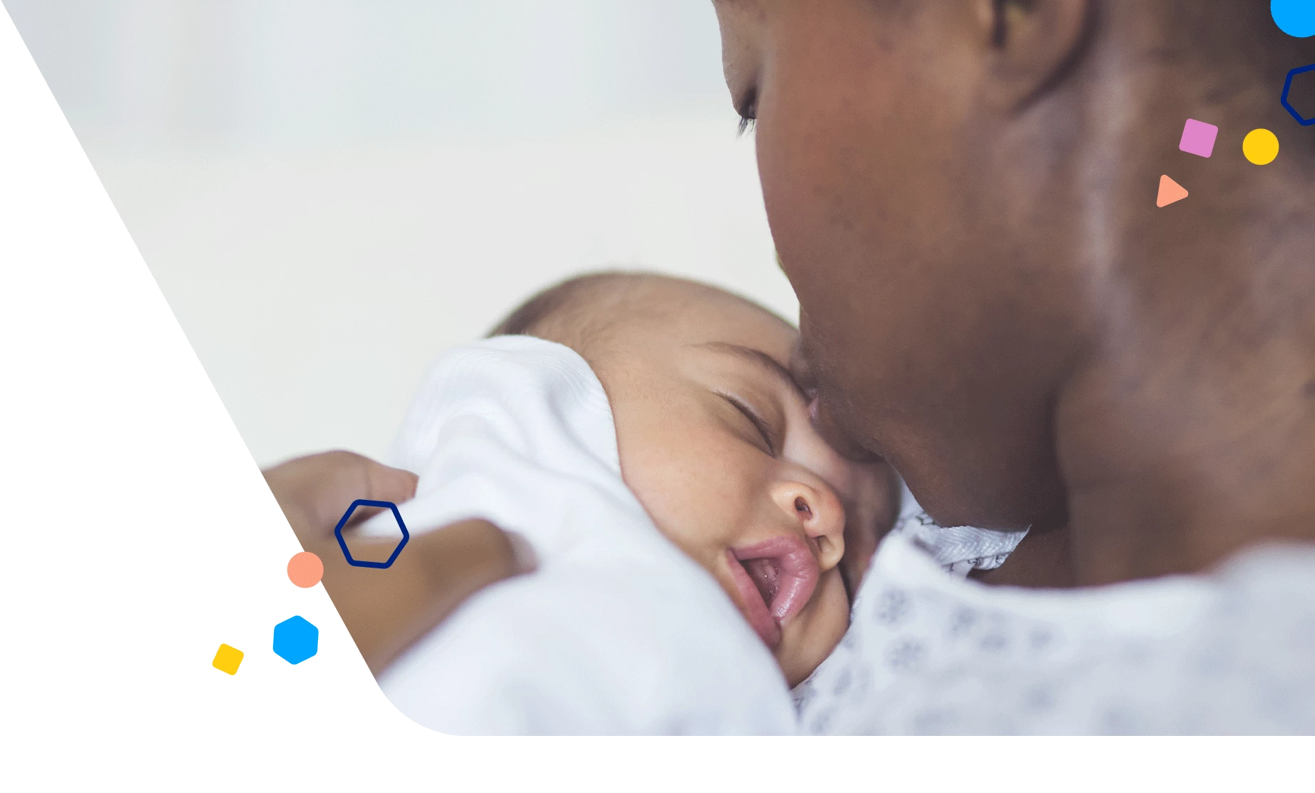 Mom kissing newborn on the forehead while in the hospital