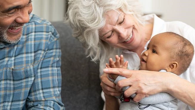 Grandparents playing with infant grandson