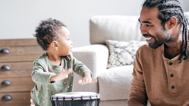 Niña tocando la batería con su papá