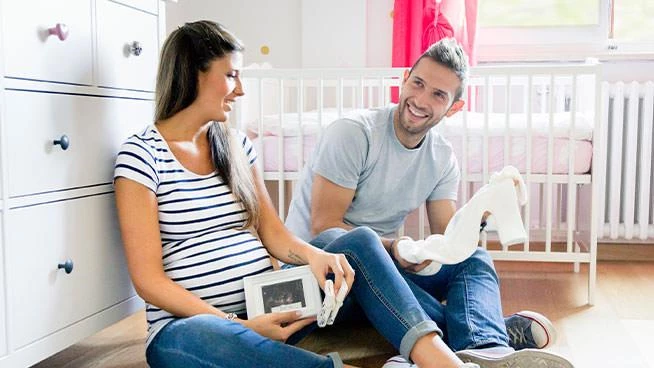 Expecting couple talking in baby's nursery