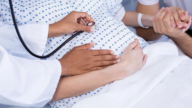 Doctor checking on pregnant mom in the delivery room