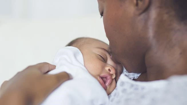 Mom kissing newborn on the head