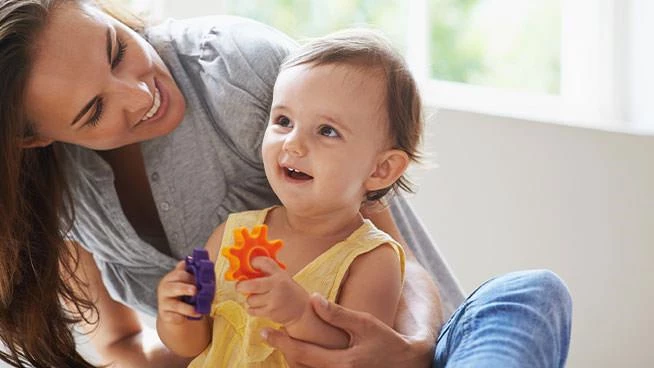 Mamá y niña pequeña jugando con juguetes