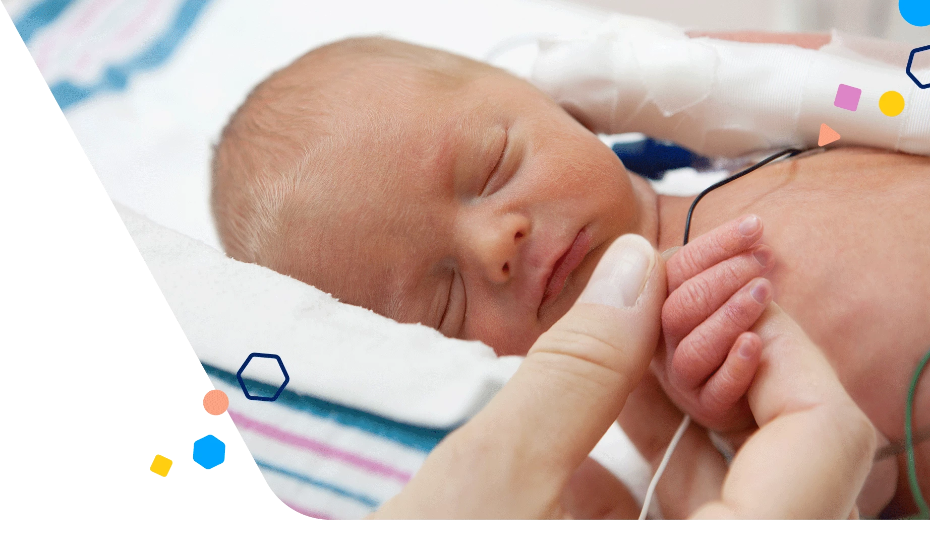 Mom holding the hand of her sleeping preemie