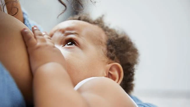 Mom breastfeeding baby as baby looks up at mom