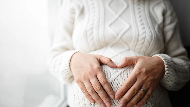 Esperando a mamá haciendo un corazón con las manos sobre la barriga