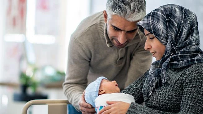 Dad and mom looking lovingly at new baby