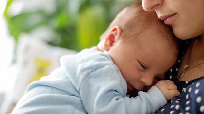 Preemie baby snuggling on mom's chest