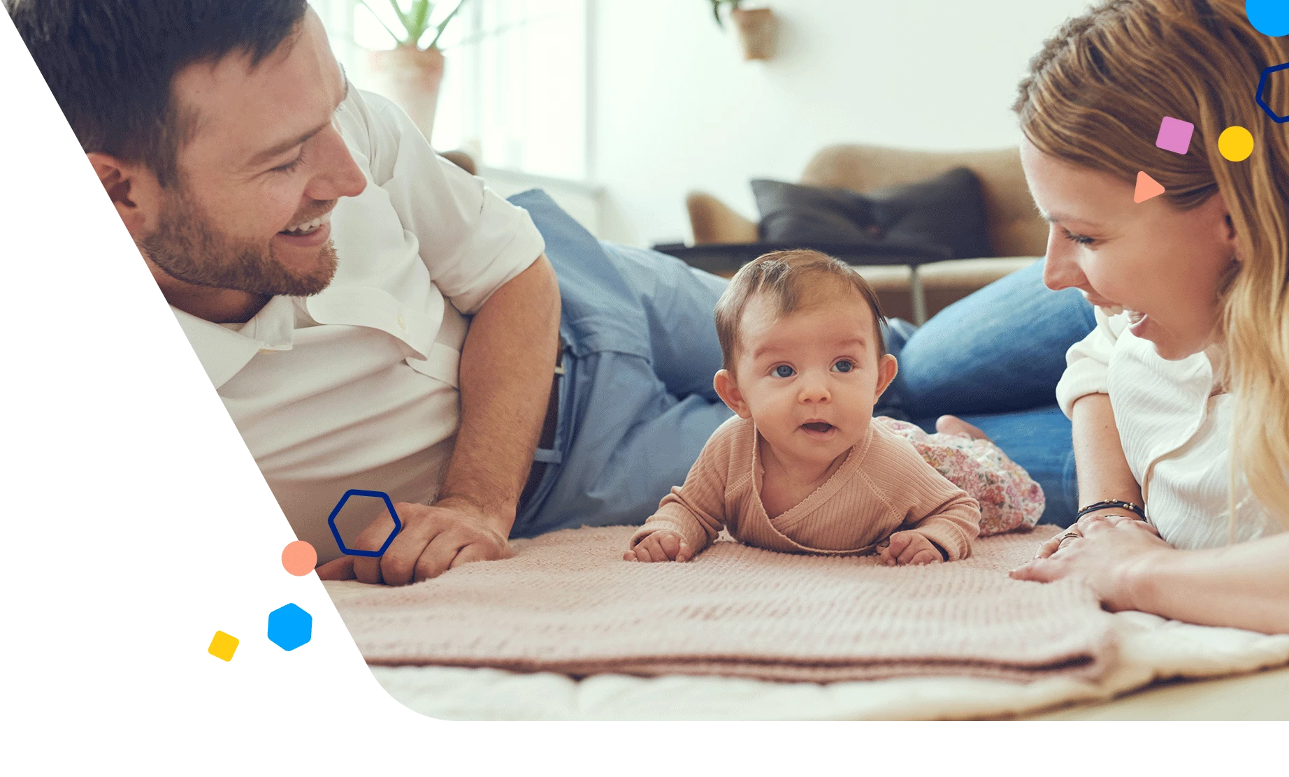 Dad and mom laying on the floor with 5 month old baby during tummy time