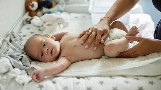 Mamá colocando su mano sobre el estómago del bebé.