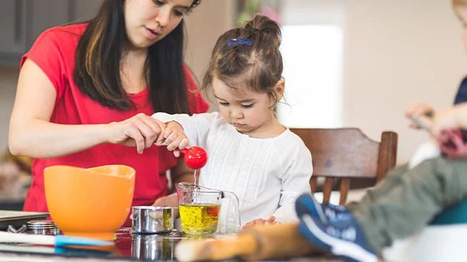 Mom cooking with toddler daughter