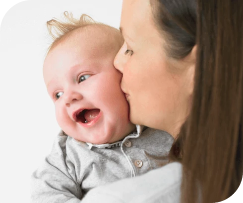 Mother kissing happy baby on the cheek