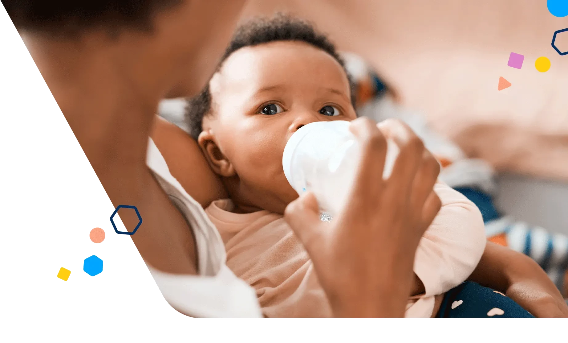 Mom holding her daughter as baby drinks a bottle