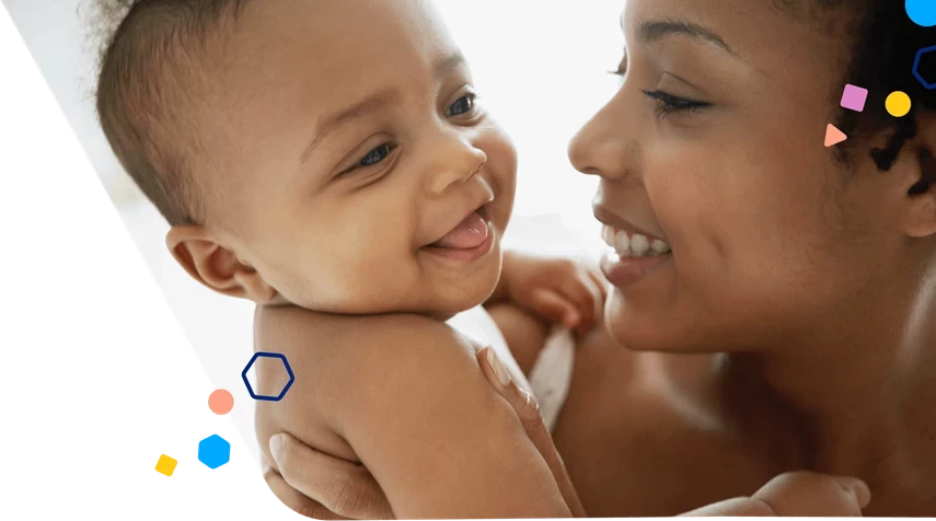 Mom holding infant and smiling