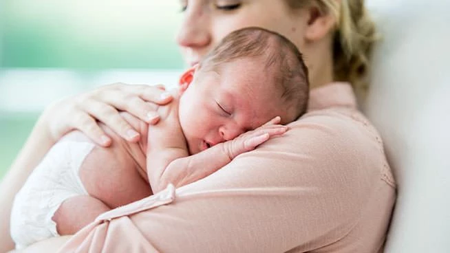 Mamá acurrucando al bebé recién nacido