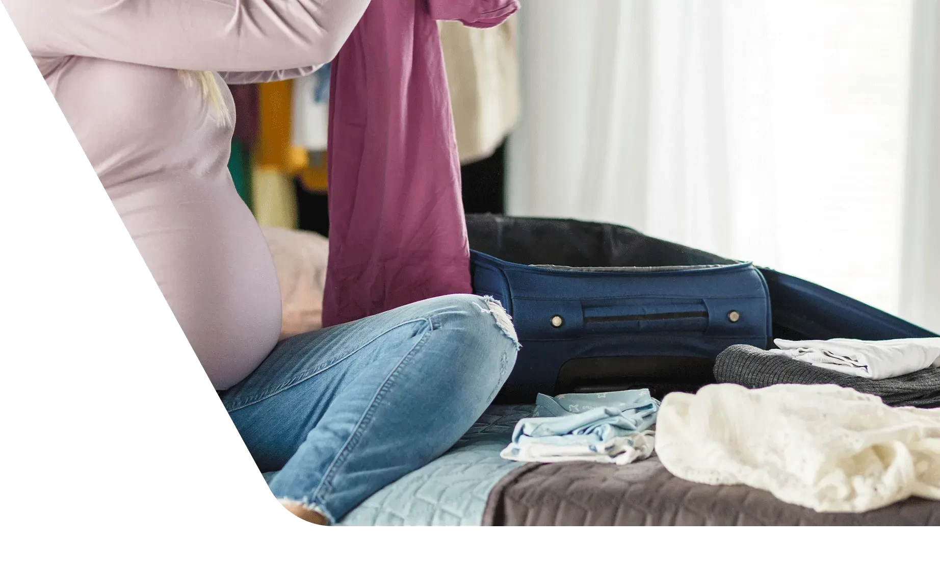 Pregnant woman packing suitcase