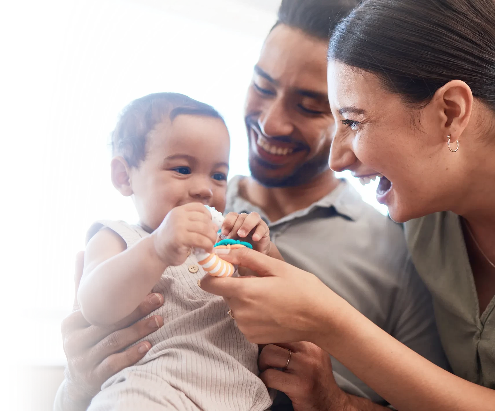 Two happy parents playing with their child