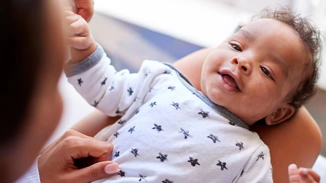 Bebé feliz acostado en el regazo de su mamá