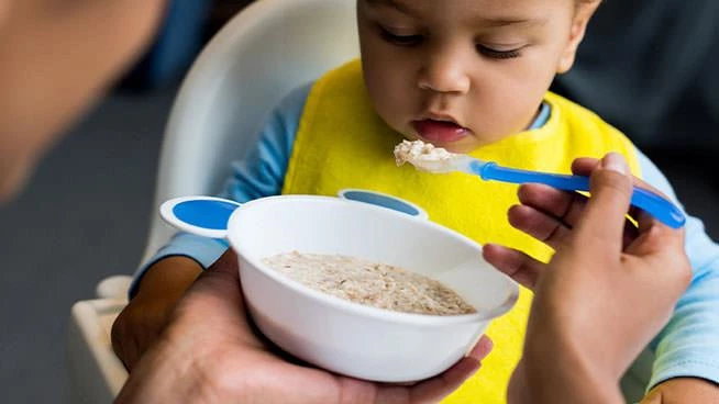 Mom feeding cereal to her infant