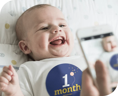 Parent taking picture of baby wearing 1 month Belly Badge™