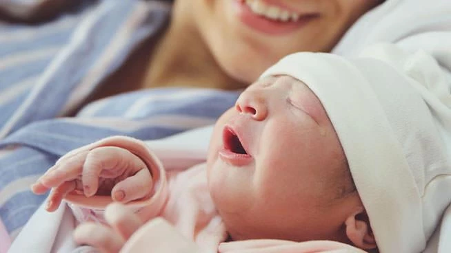 Close up of newborn baby laying next to mom