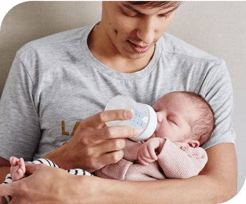 Papá sosteniendo al bebé y dándole el biberón