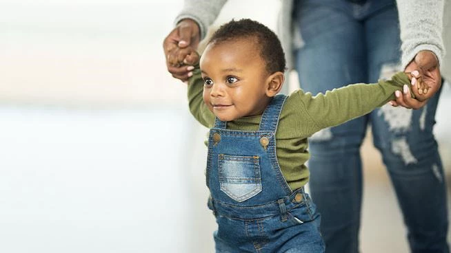 Mom helping toddler walk