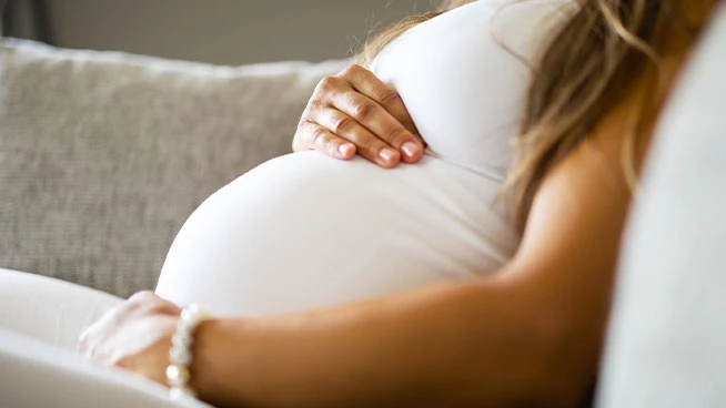 Pregnant mom laying down and touching her stomach