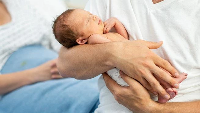 Dad holding premature baby at the hospital