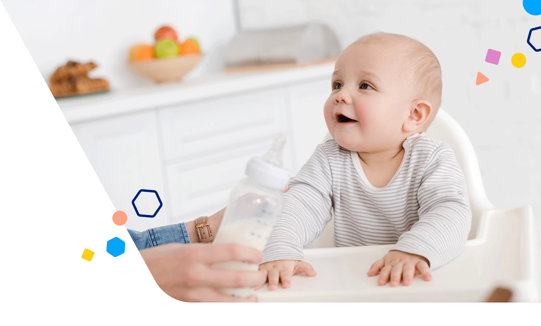 Baby in a high chair getting a bottle from mom